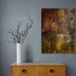 Warm earthy abstract portrait in red, brown and yellowposter format displayed in a grey wall with wooden cabinet and vase with curly twicks