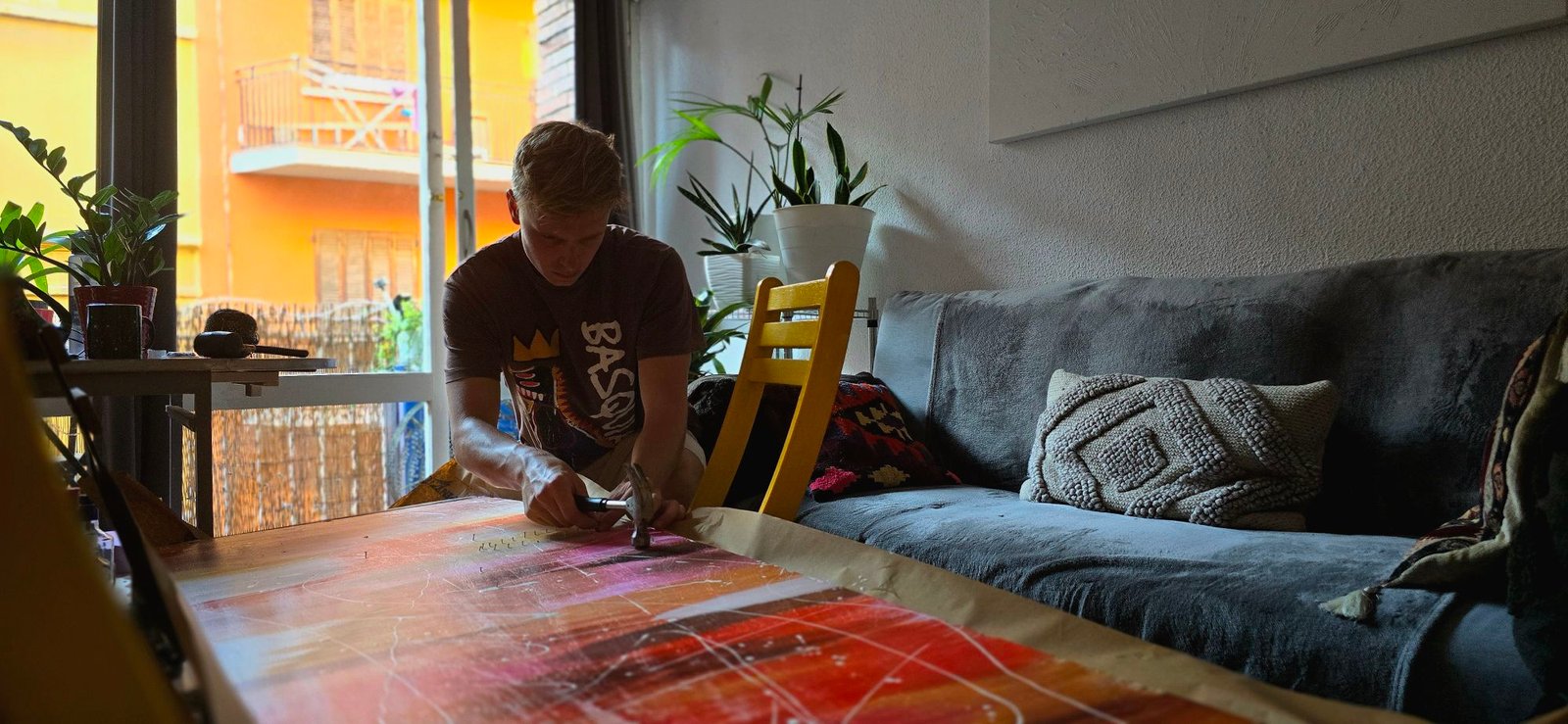 Ruben van Stegeren, founder of ARTvS, working on a colourful abstract art piece with a hammer
