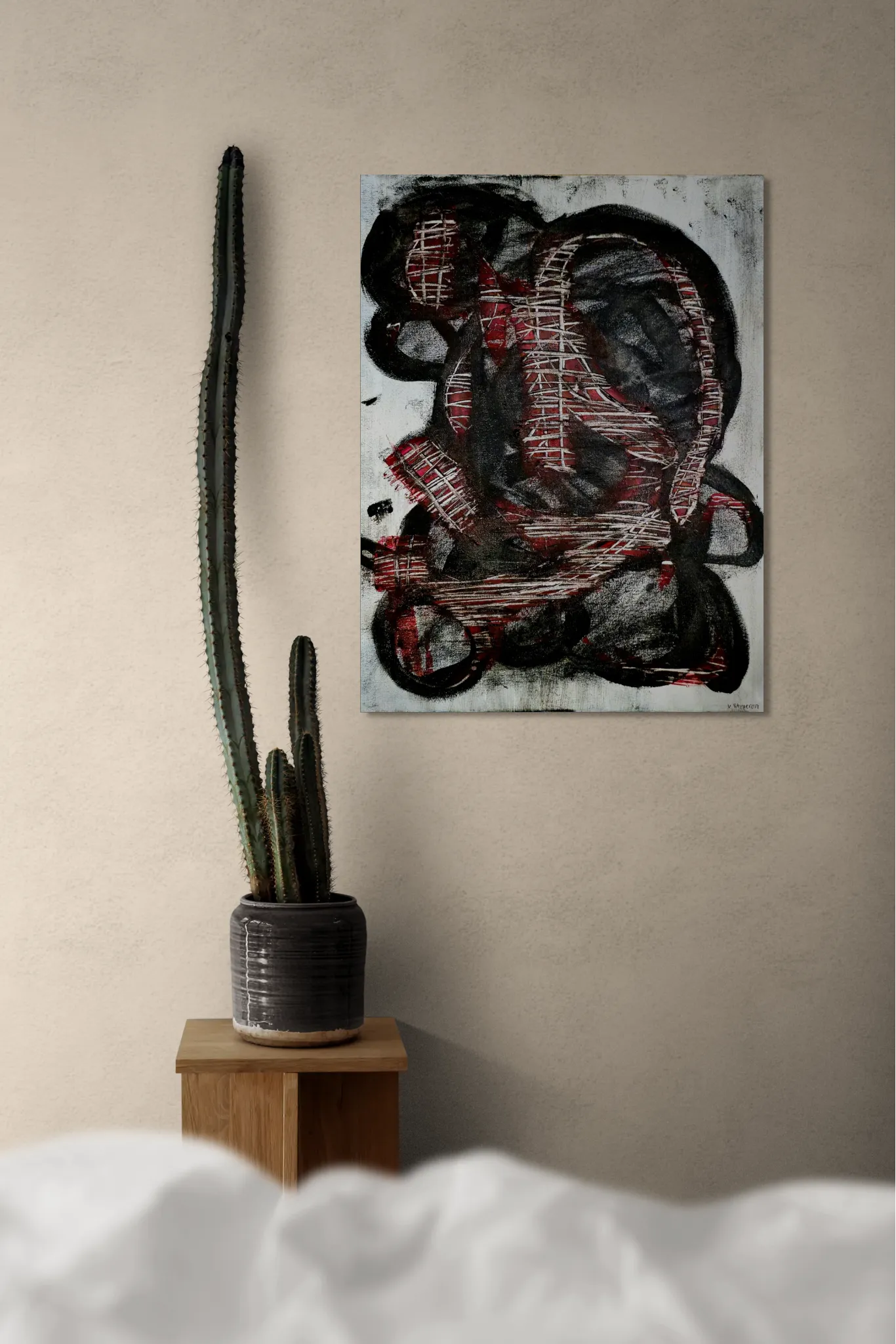 Dark and conceptual abstract portrait in white, black and redposter format displayed in a living space with coffee table and cactus