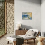 Dreamy glowing abstract landscape in blue and goldposter format displayed in a living space with glass walls, reclined couch, accent rock wall