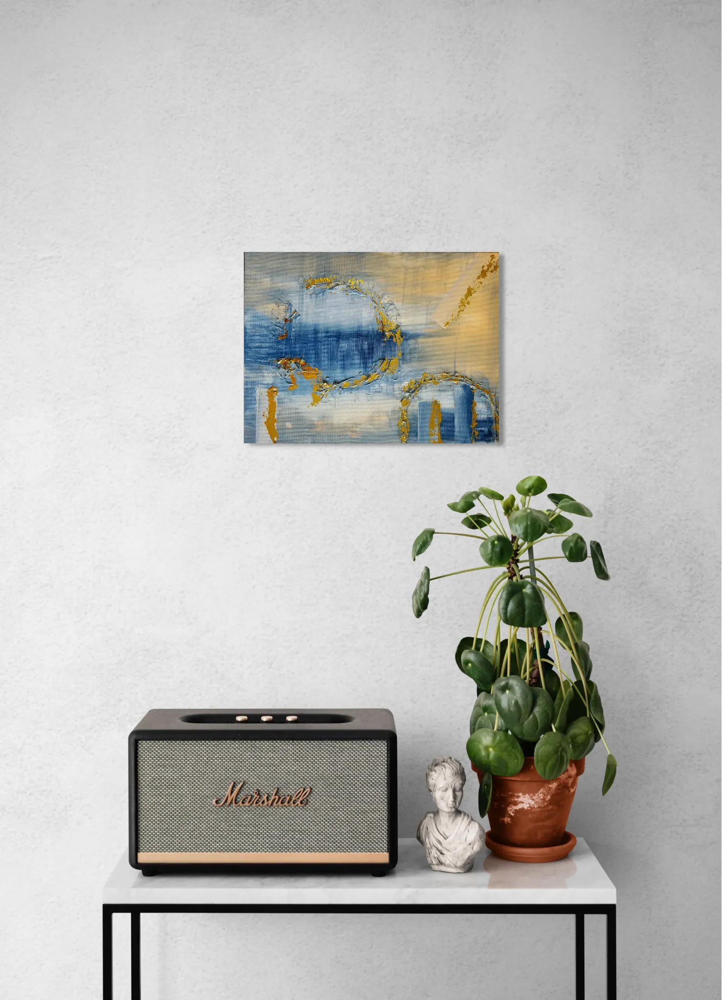 Dreamy glowing abstract landscape in blue and goldoriginal format displayed in a console table with speaker and potted plant