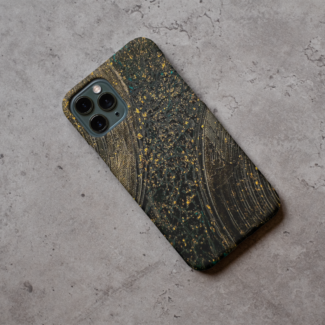 Phone case displayed on a grey concrete surface featuring the artwork “Bangkok”, a textured gold and black abstract piece.