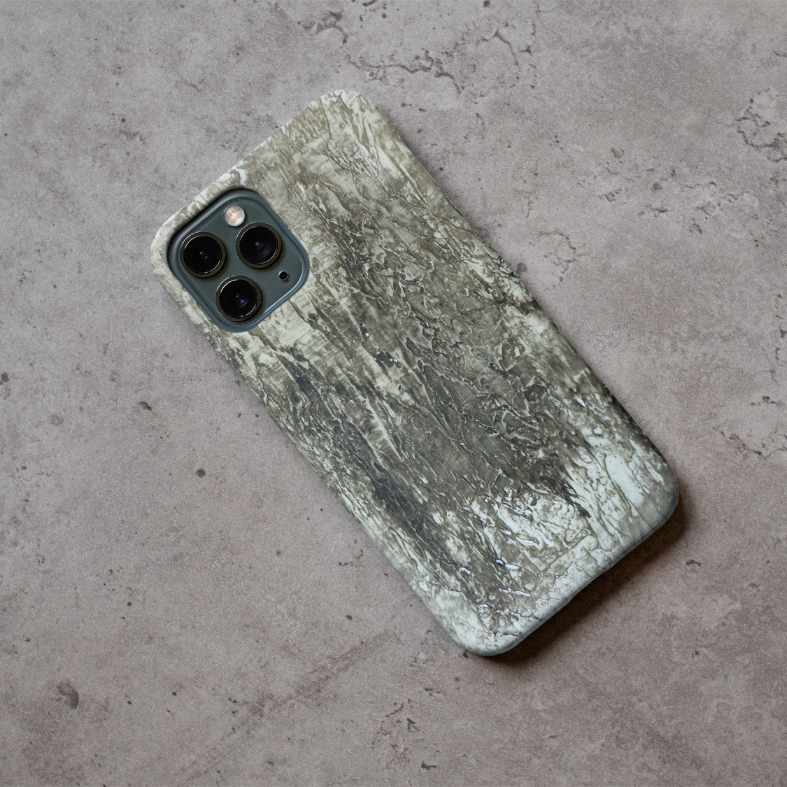 Phone case displayed on a grey concrete surface featuring the artwork “Berlin”, a grey monochromatic abstract piece.