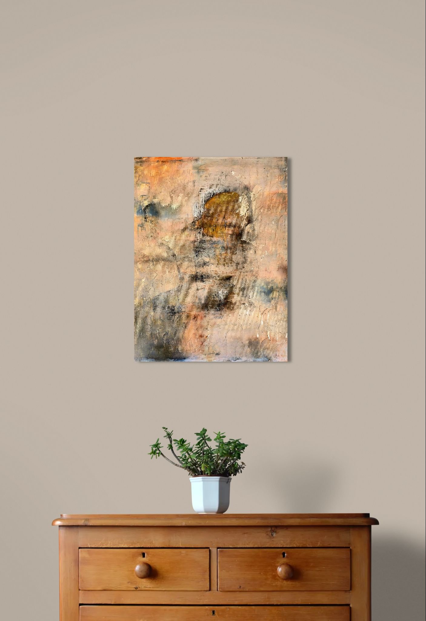 Abstract art poster with hidden face and warm layered colors behind wooden cabinet with small potted plant