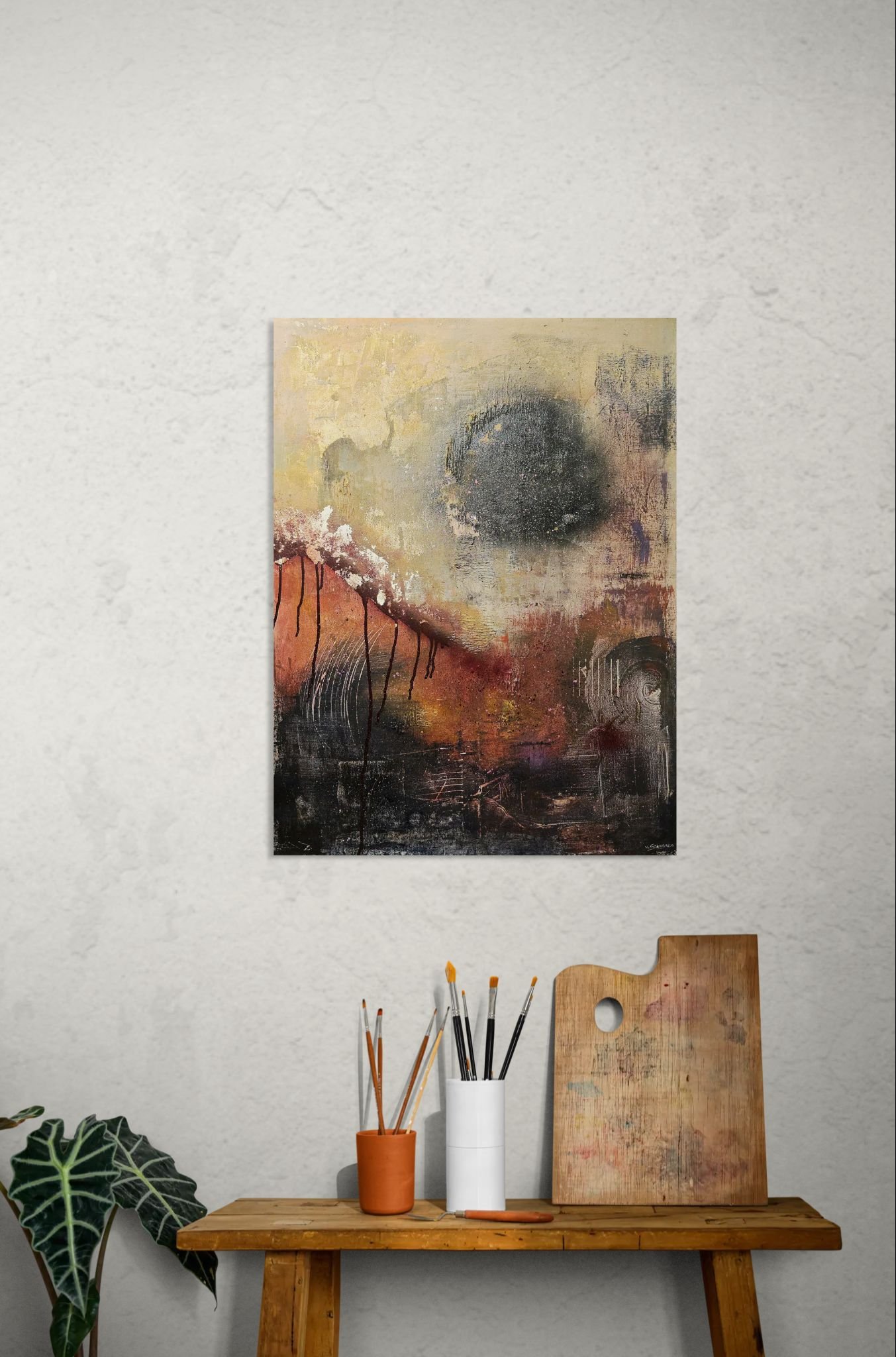 Abstract poster with autumn colors behind artists side table with brushes and palette
