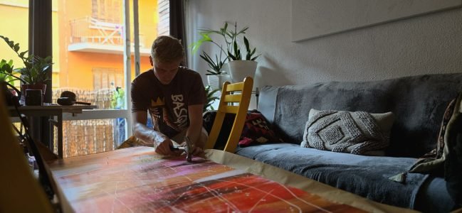 Ruben van Stegeren, founder of ARTvS, working on a colourful abstract art piece with a hammer